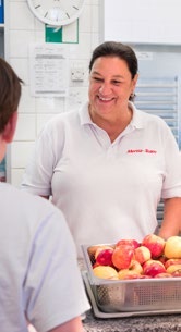 Eine Mitarbeiterin des Mensa-Teams an der Ausgabe mit frischem Obst.